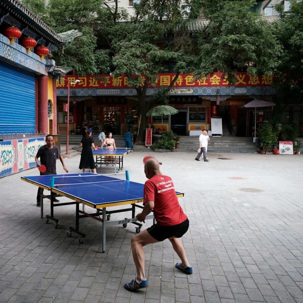 A man is playing ping pong in a courtyard