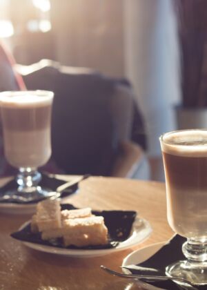 cake on white saucer between two clear footed glass