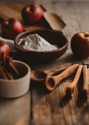 a wooden table topped with apples and cinnamon sticks