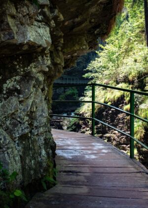 a wooden walkway leading to a large cliff