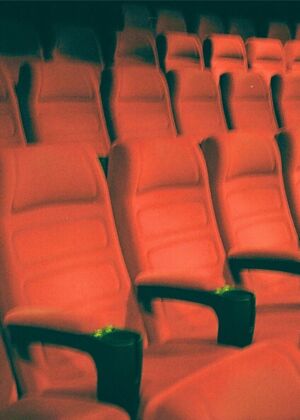 a row of empty red seats in a theater